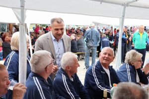 Mnoštvo umirovljenika Međimurja sjedi na klupicama ispod šatora na sportskim susretima u Gornjem Mihaljevcu te im se obraća župan Matija Posavec